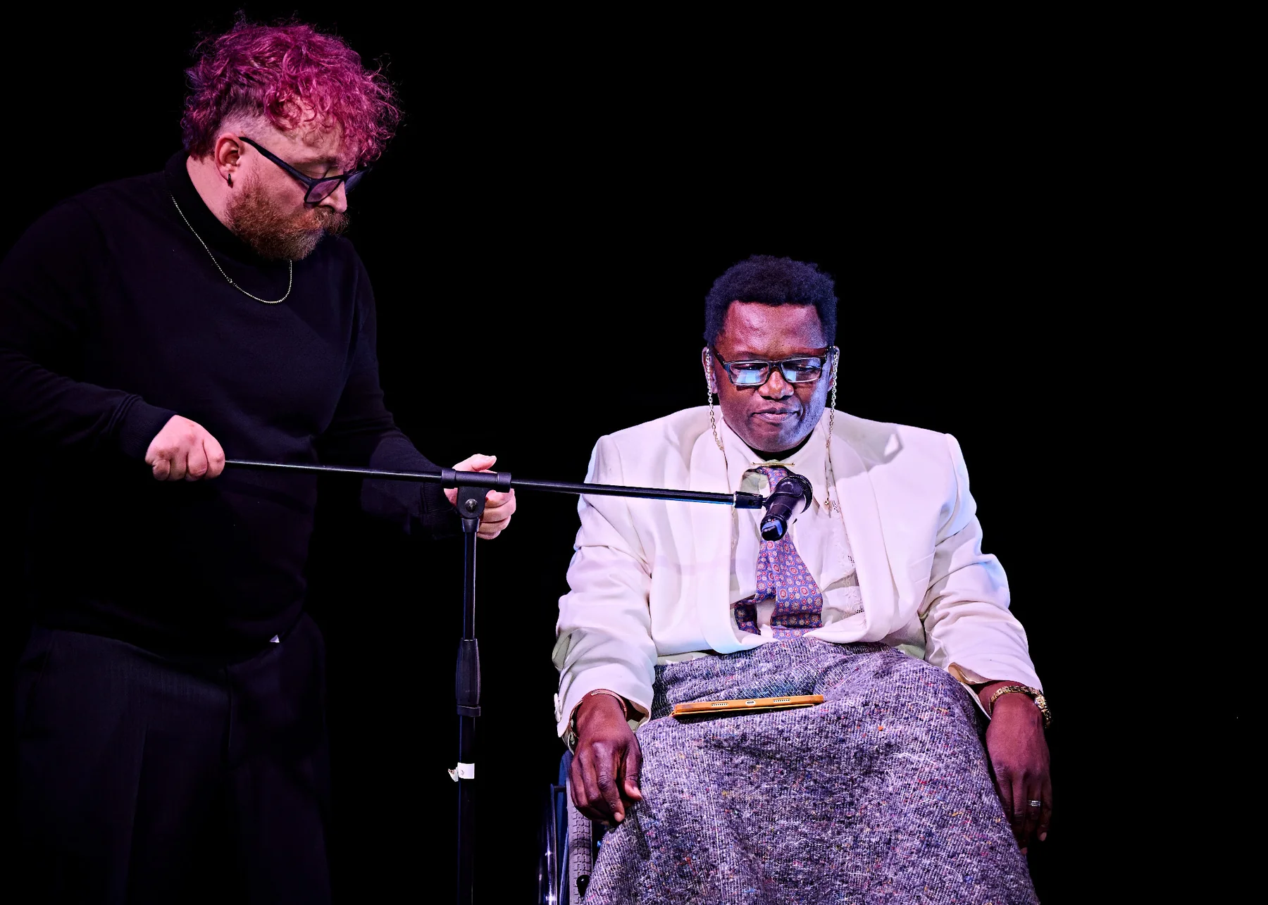 Danny Muir adjusting a microphone stand during Magama Does Sci-Fi